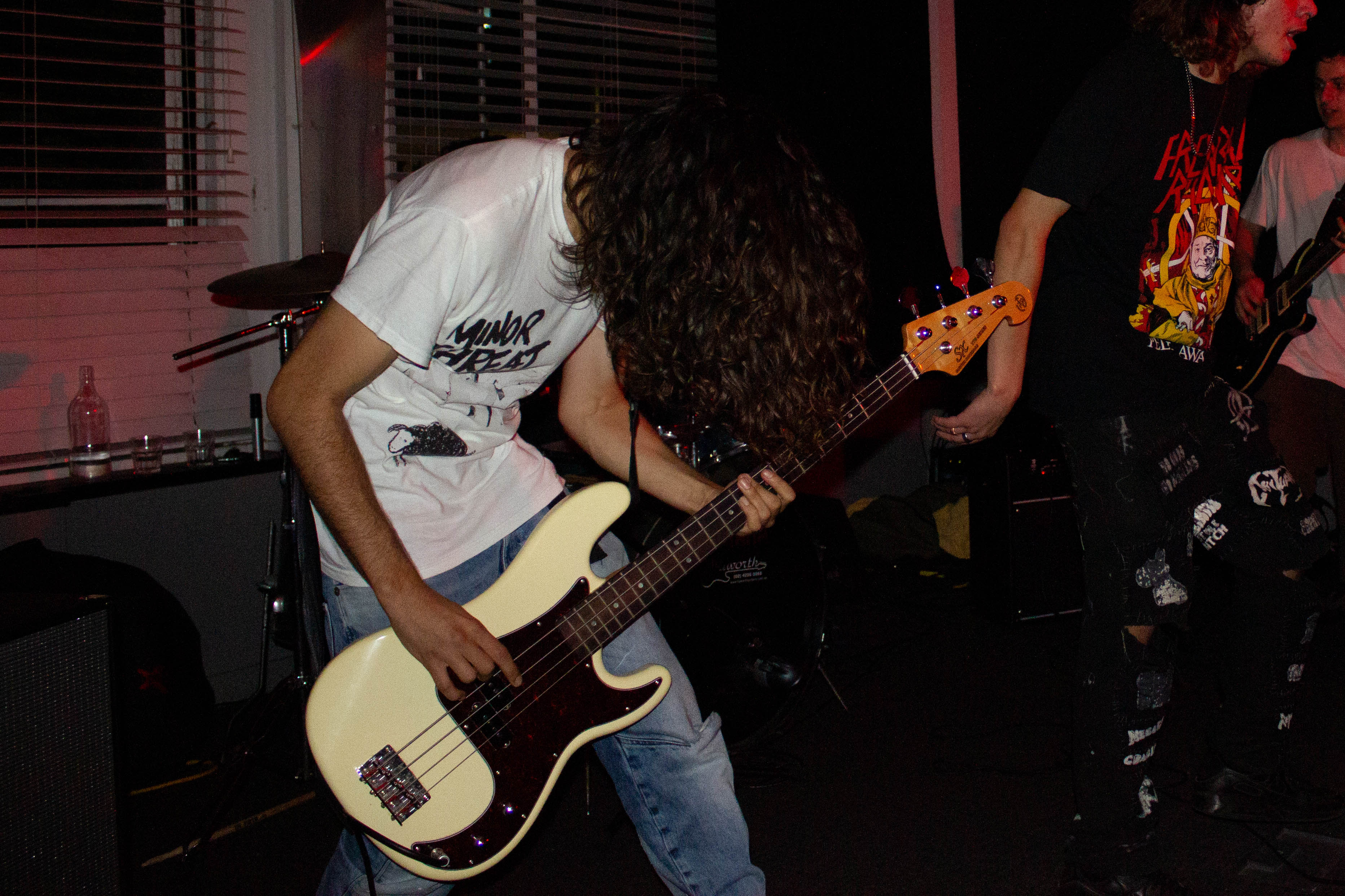 Pipoltr's bassist in flash lighting, leaning sideways